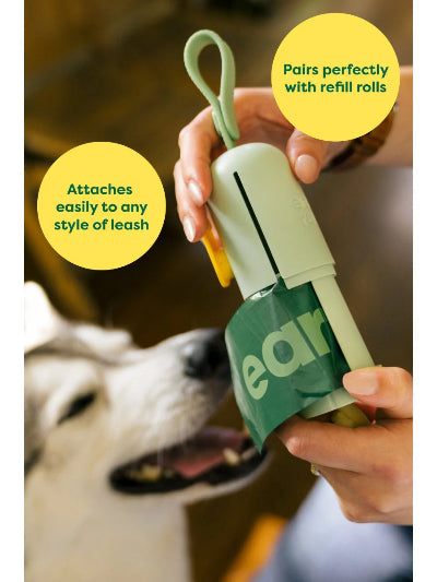 Dog pet waste bag holder with text indicating compatibility with refill rolls and leashes, with a dog in the background.