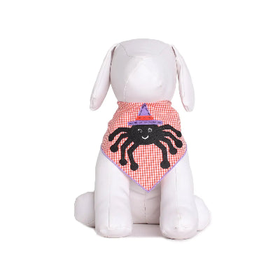 White dog wearing a Halloween-themed bandana with a spider design on a white background