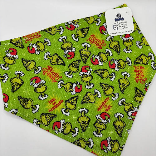 Green dog bandana featuring Grinch wearing Santa hat and catchy sayings on white background.