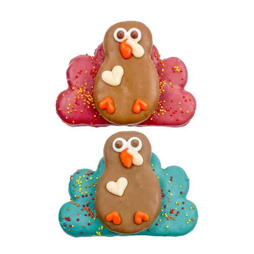Two dog treats shaped like turkeys on white background