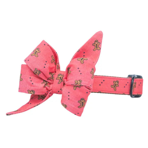 Rose colored dog collar with bow featuring Gingerbread Men on white background.