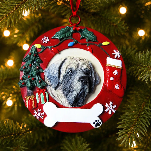 A personalized Christmas ornament shaped like a red circular wreath, hanging on a Christmas tree. The center features a photo of a Mastiff, surrounded by festive decorations including a small Christmas tree, gift boxes, a stocking, holly, a bone, and colorful holiday lights.
