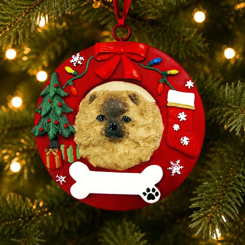 A round red Christmas ornament hanging on a lit Christmas tree. The ornament features a custom pet portrait of a Pomeranian, surrounded by festive holiday decorations including a red bow, colorful lights, a small green Christmas tree, a stocking, snowflakes, a white bone, and a paw-print detail.