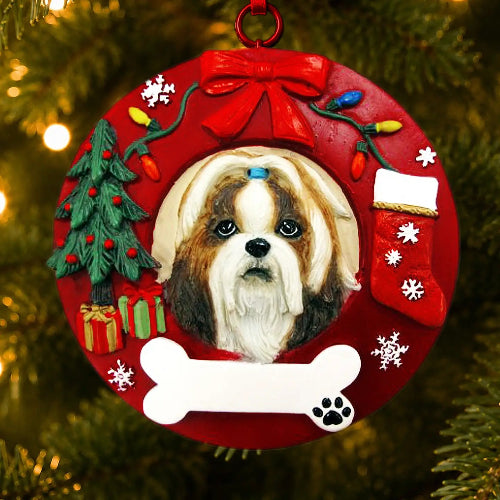 A round red Christmas ornament featuring a portrait of a Shih Tzu dog, decorated with a red bow, holiday tree, stocking, gifts, and a white bone at the bottom, hanging on a Christmas tree.