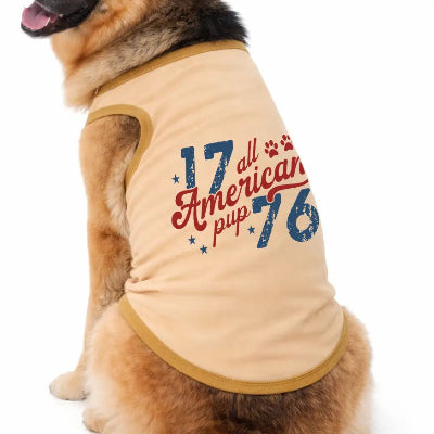Dog wearing a beige shirt with '17 all American pup 76' text on a white background