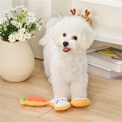 White dog with colorful toys on a wooden floor next to a vase of flowers.