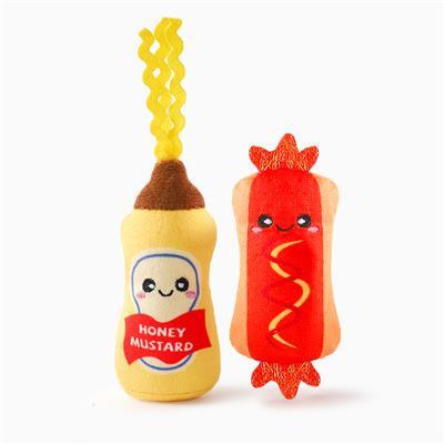 Plush toys resembling a bottle of honey mustard and a hot dog with mustard on a white background