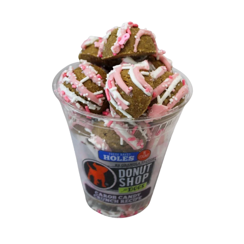 Clear package of pink & white drizzled donut holes dog treats on white background.