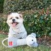 Dog playing with gray and white striped panda rope dog toy.