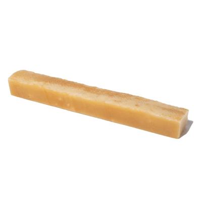 Rectangular piece of dehydrated yak cheese on a white background