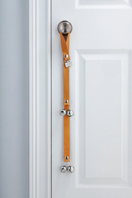 Bourbon PoochieBells Premium Full Grain Leather Dog Doorbells handing on doorknob of white door.
