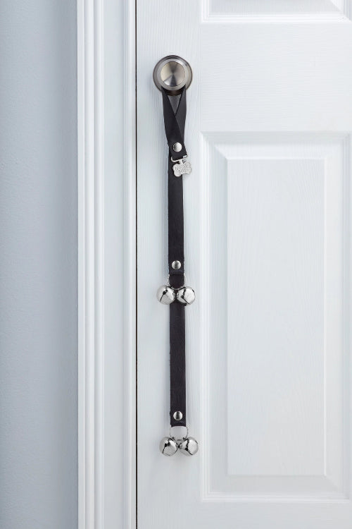 Black Bird PoochieBells Premium Full Grain Leather Dog Doorbells hanging on doorknob of white door.