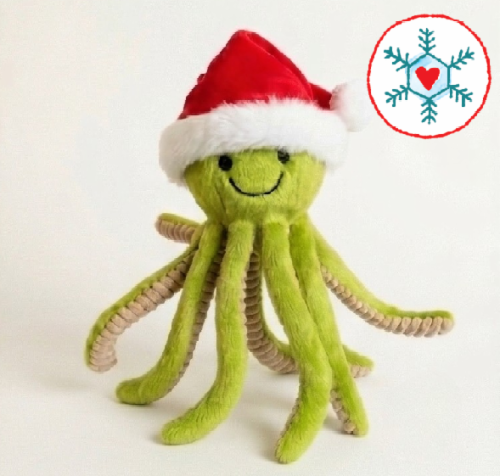 Green octopus toy wearing Santa hat on white background.