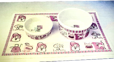 Two small bowls with a matching placemat featuring cartoon cat designs on a white background.