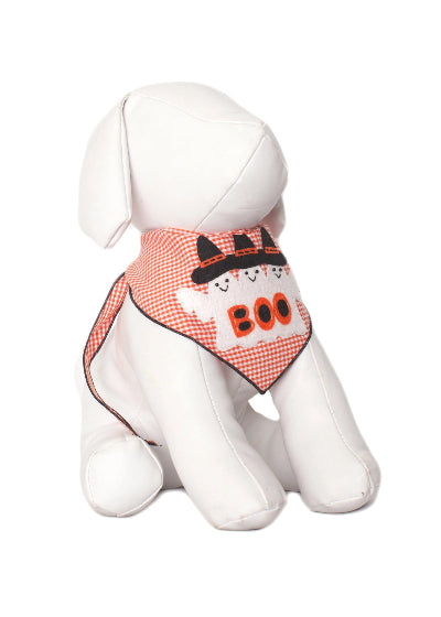 A white plush dog toy wearing a orange and white gingham bandana with a black cat wearing a bow tie and the word 'BOO' in orange.