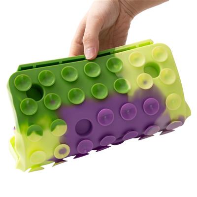 Green and purple silicone mold with suction cups held by a hand on a white background