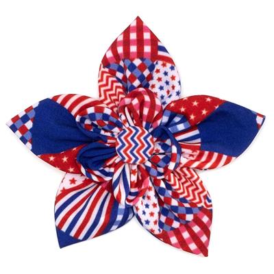Decorative flower made of red, white, and blue fabric with a white background