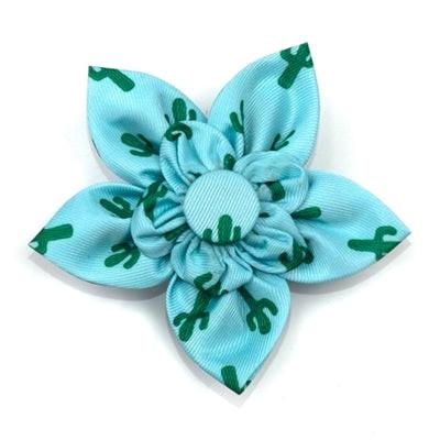 Light blue flower-shaped hair clip with green patterns on a white background
