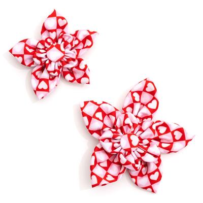 Two red and white patterned collar bows on a white background