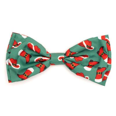 Christmas-themed bow tie with red boots and green background on a white background