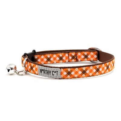 Cat collar with orange plaid pattern and brown accents with bell and label showing "Worthy Cat" on a white background