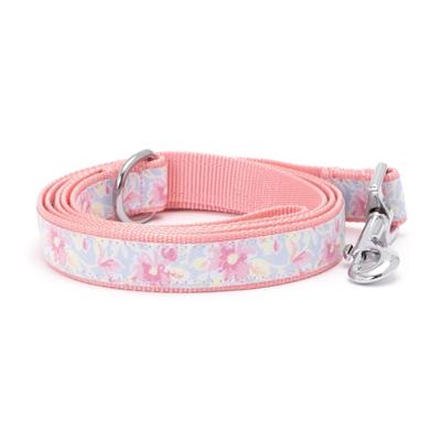 Floral-patterned dog leash with pink handle on a white background