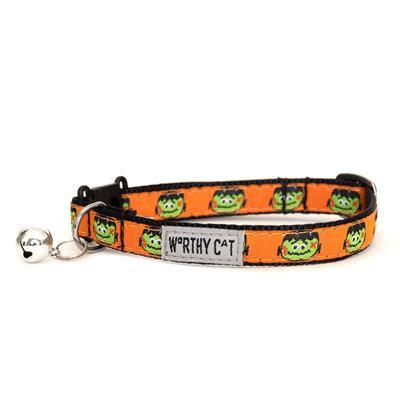 Orange cat collar with green Frankenstein faces, bell and "Worthy Cat" label on white background 