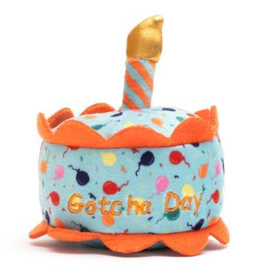 Plush toy shaped like a birthday cake with candles on a white background