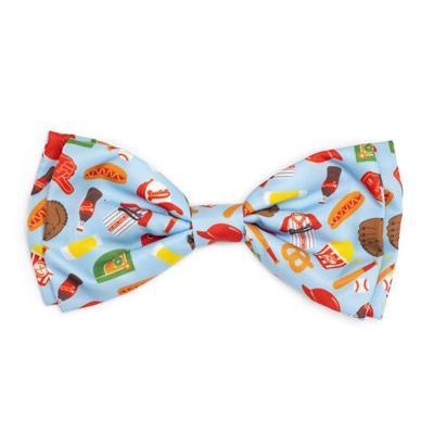 A multicolored bow tie with a pattern that includes hot dogs, fries, and other fast food items on a light blue background.