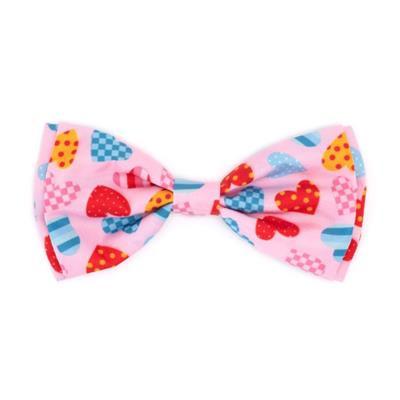 Colorful bow tie with heart and candy patterns on a pink background