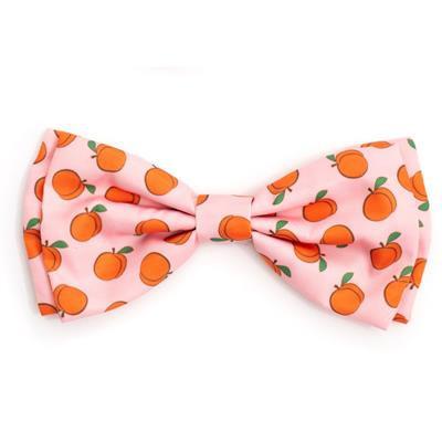 Pink dog bow tie with patterns of peaches on white background