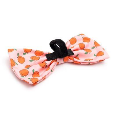 pink dog bow tie with patterns of peaches and Velcro closure on white background