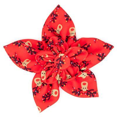 Red flower-shaped hair bow with gold and black patterns on a white background