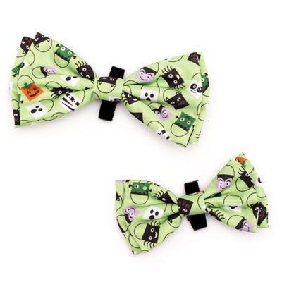 Two green bow ties with Halloween-themed designs on a white background