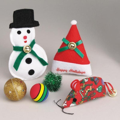 Variety of Christmas themed cat toys including felt snowman, felt santa hat, cloth mouse with bell, gold ball, rainbow colored ball and tinsel ball on gray background.